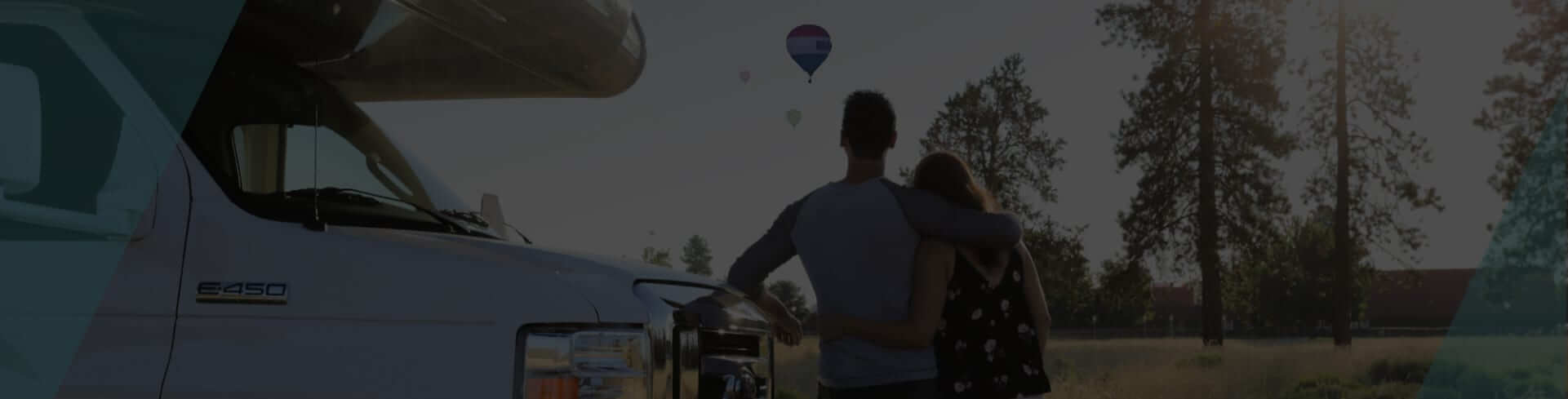 The image depicts a couple standing outside near a large vehicle, possibly an RV, with one of them h...